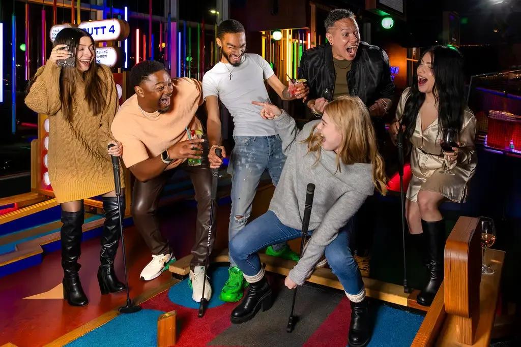 A group of friends celebrating together on a 9-hole mini golf course