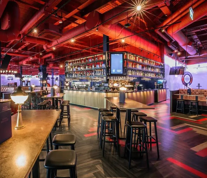 Image of a Puttshack venue's bar and high top tables