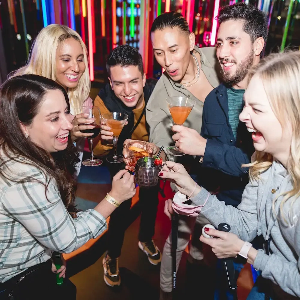 A group of happy adults cheering with their cocktails