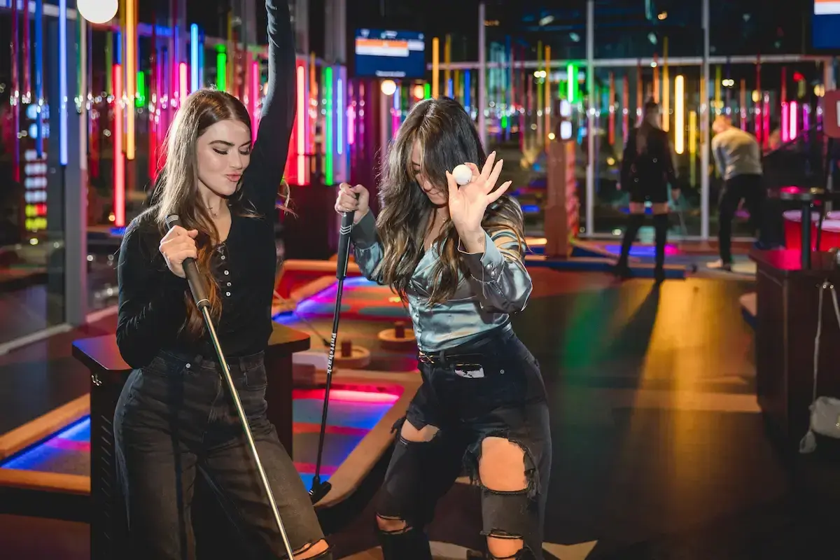 two girls celebrating holding putts and a golf ball