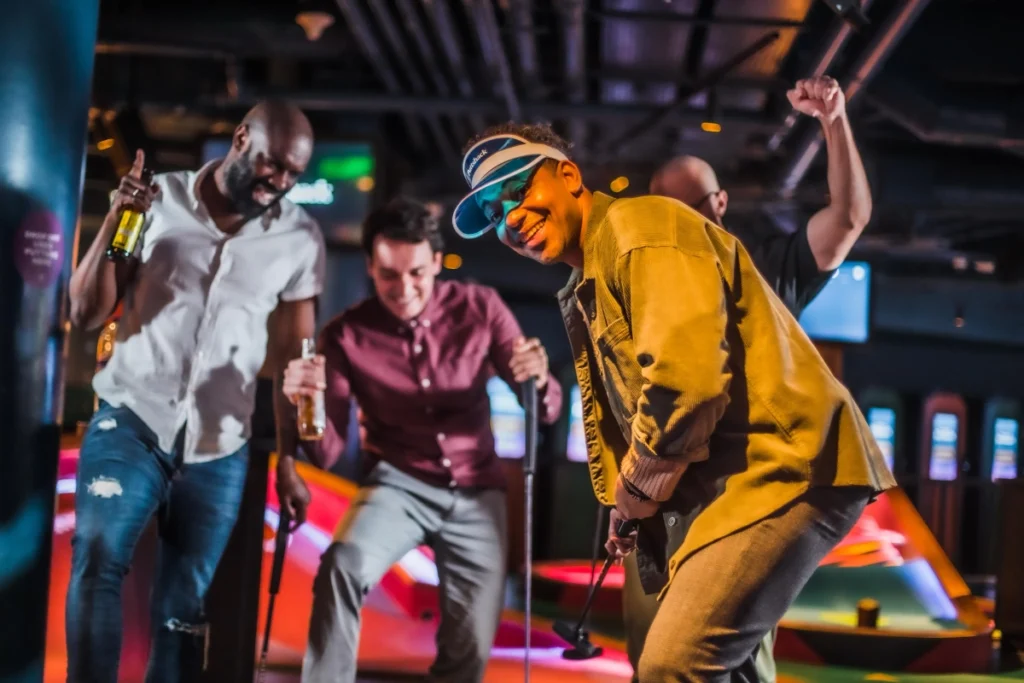Male friends partying and golfing together at Puttshack
