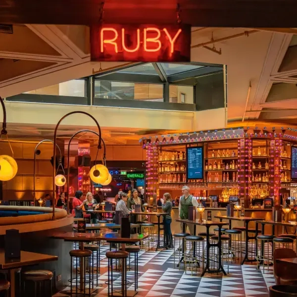 inside a puttshack dining area with a neon RUBY sign