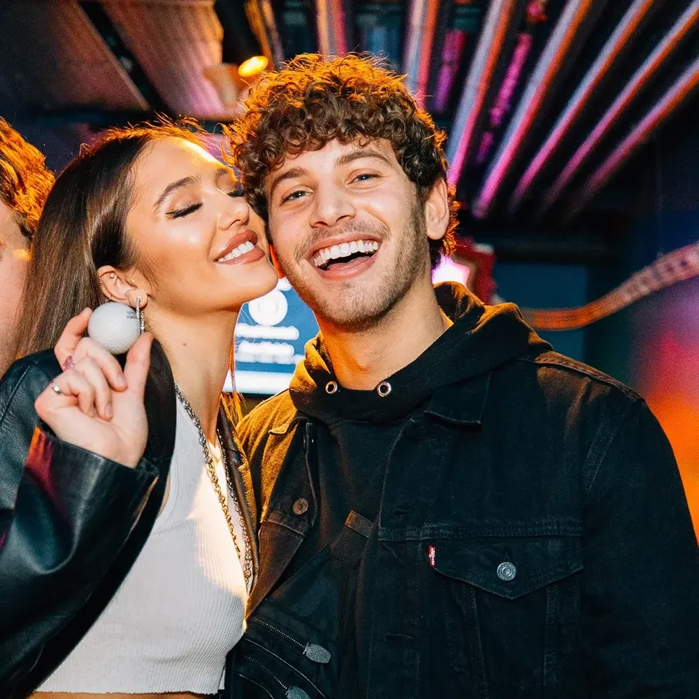 couple smiling and holding a golf ball