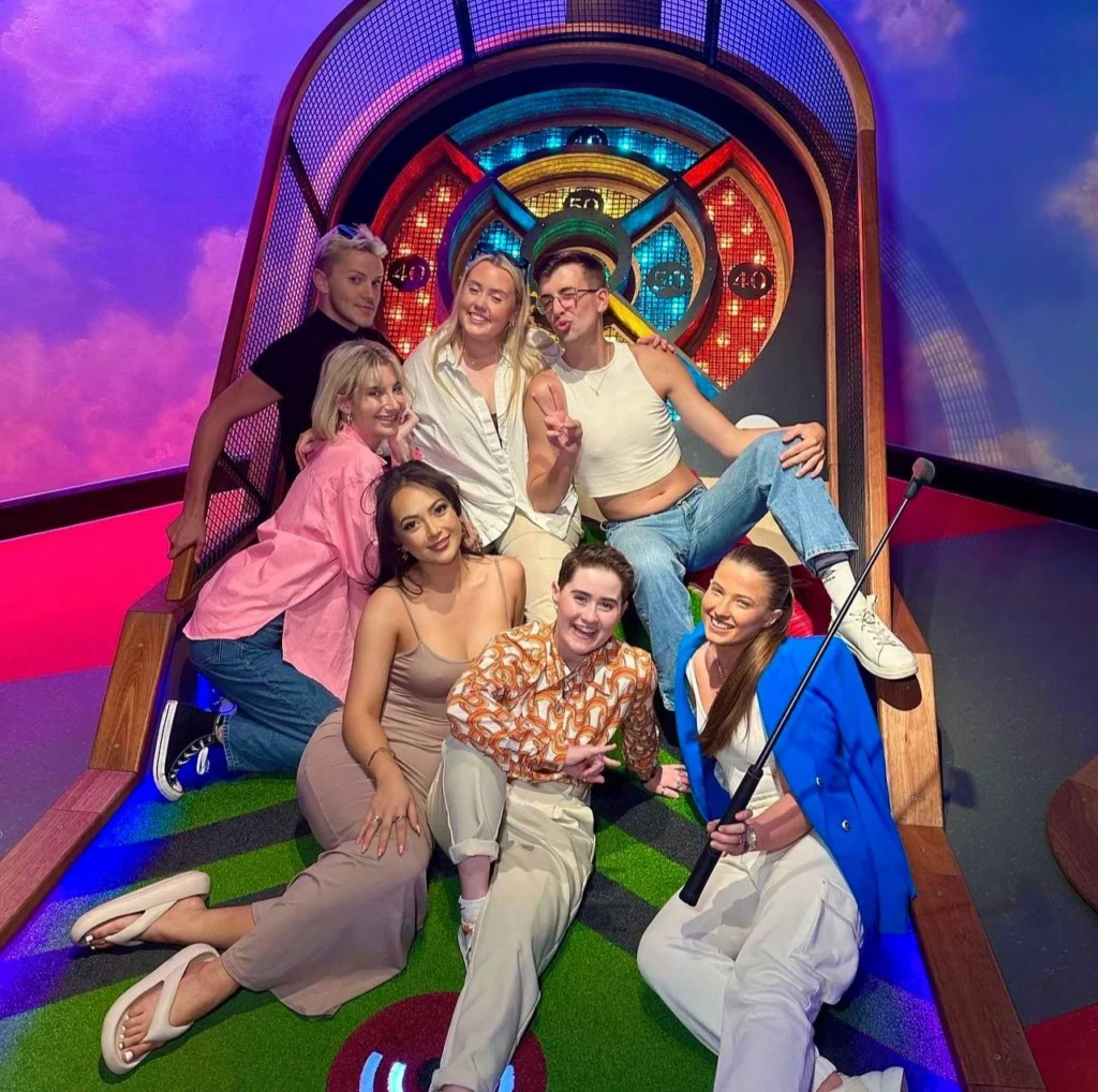 Group of adults posing on ski-ball hole