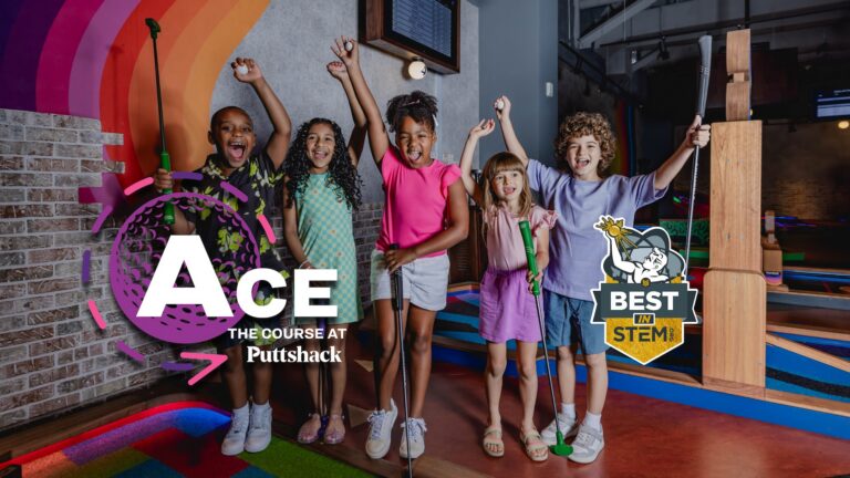 A group of children standing on an indoor mini golf course holding mini golf clubs with arms raised, with on-screen graphics reading “Ace: The Course at Puttshack” and “Best in STEM,” and colorful course elements and a rainbow wall mural visible in the background