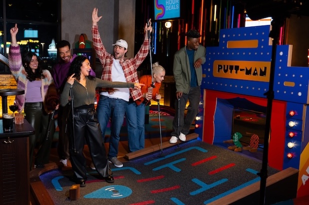 Group gathered around an indoor mini golf course
