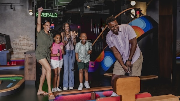 A group of a family playing Puttshack on the course