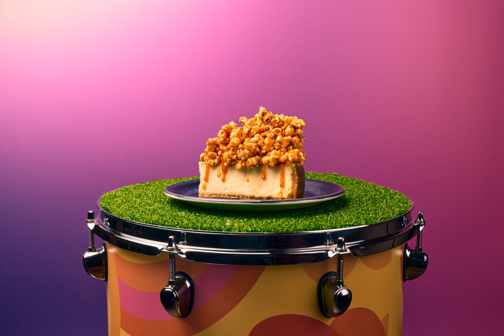 A caramel New York Cheesecake sitting on a mini golf drum
