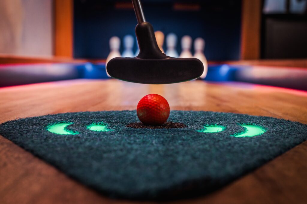 A golfball on the tee turf ready to get putt